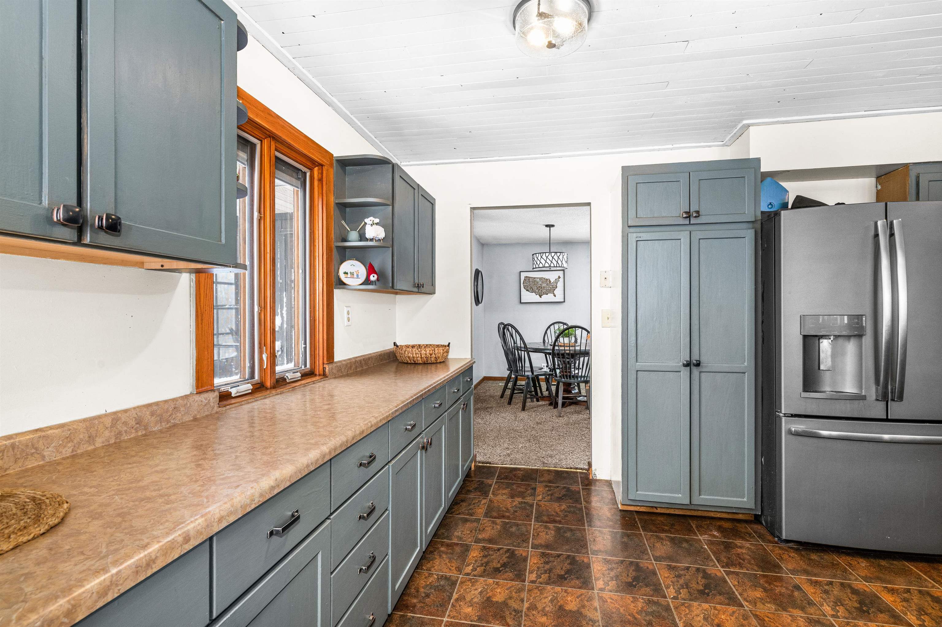 3325 Strand Road Duluth, MN 55803 - Photo 10 of 33 Kitchen featuring stainless steel fridge, painted finished cabinetry & light colored countertops..