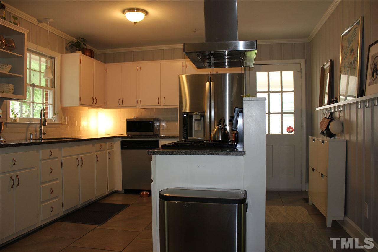904 Chatham Lane Raleigh, NC 27610 - Photo 6 of 29 a kitchen with stainless steel appliances granite countertop a refrigerator a sink dishwasher a stove and white cabinets with wooden floor