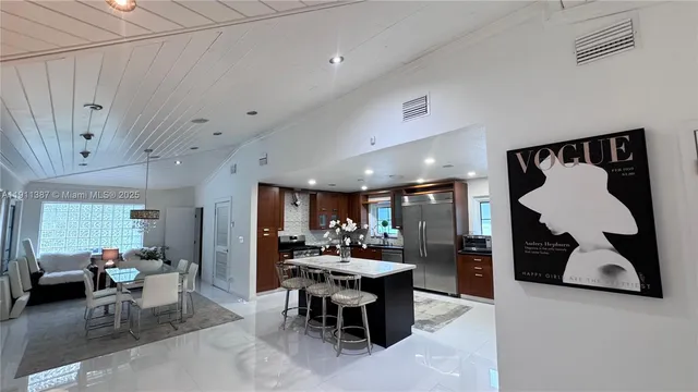 a living room with furniture a couch and a kitchen view