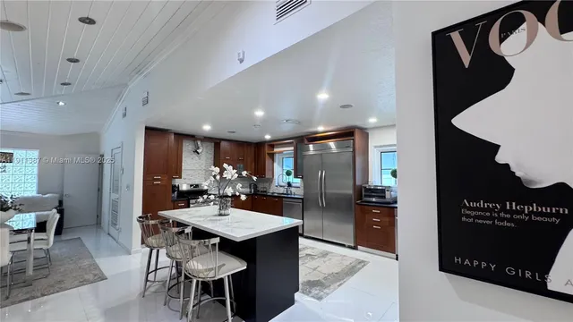 a kitchen with a dining table chairs and a refrigerator