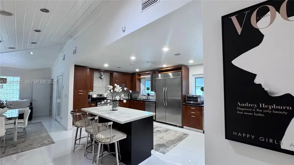 a kitchen with a dining table chairs and a refrigerator
