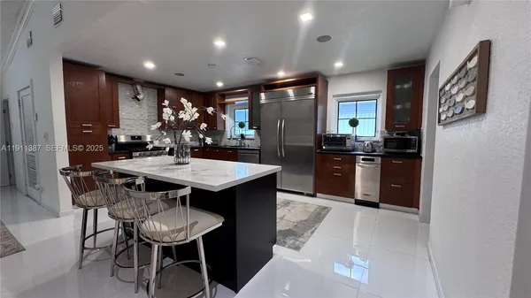 a kitchen with stainless steel appliances kitchen island granite countertop a sink and cabinets