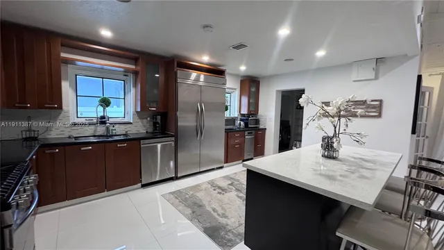 a kitchen with granite countertop a sink stove and refrigerator