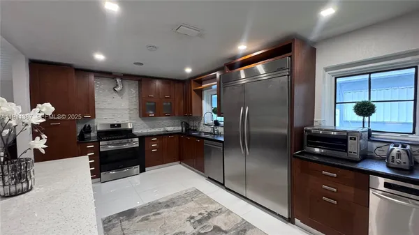 a large kitchen with lots of counter space a sink and appliances