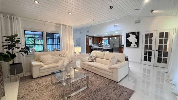 a living room with furniture and view of kitchen