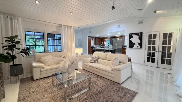 a living room with furniture and view of kitchen