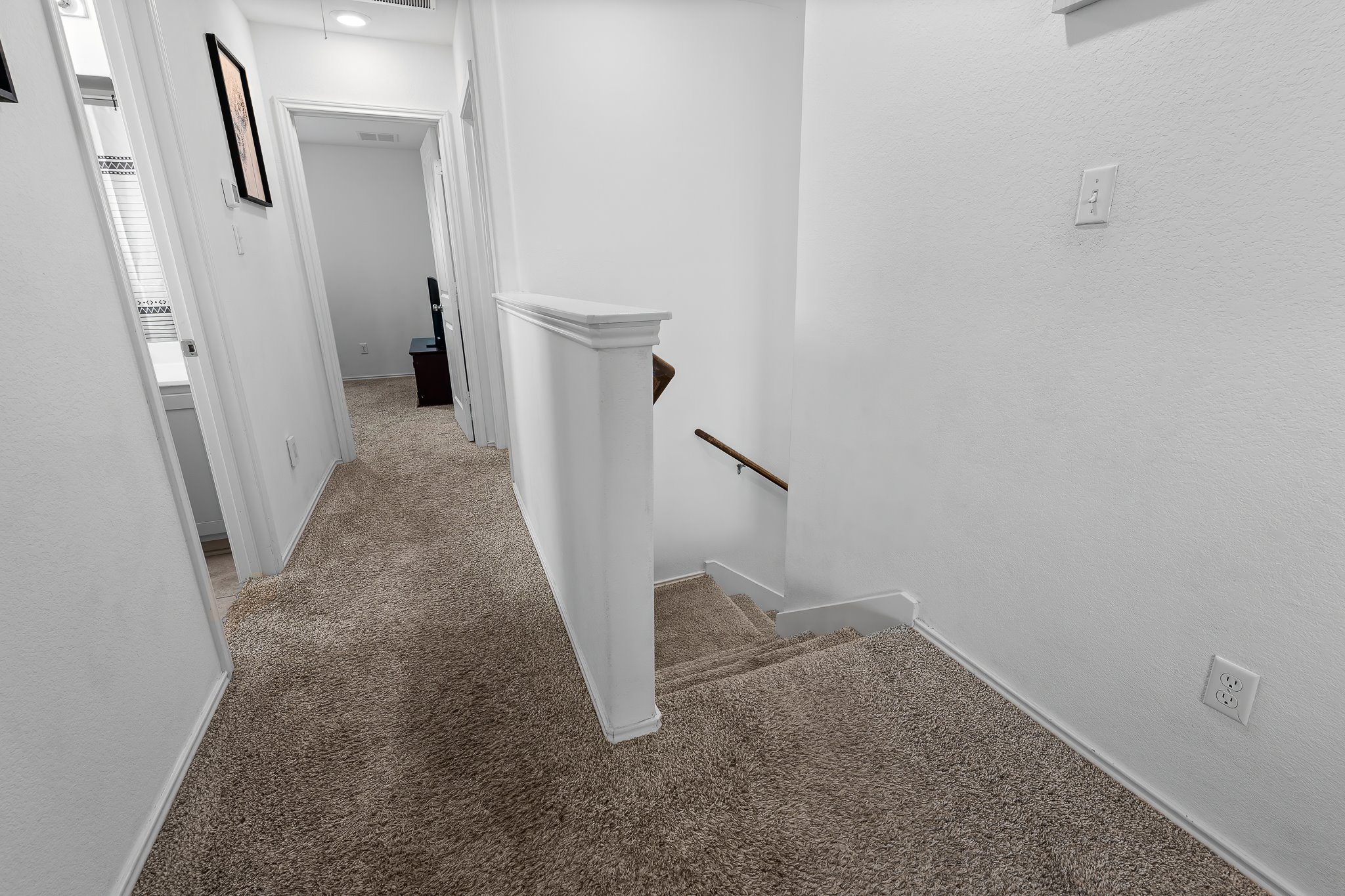 576 Greatest Gift Way Jarrell, TX 76537 - Photo 18 of 37 Neutral carpeting connects upper-level rooms and leads to a descending staircase.