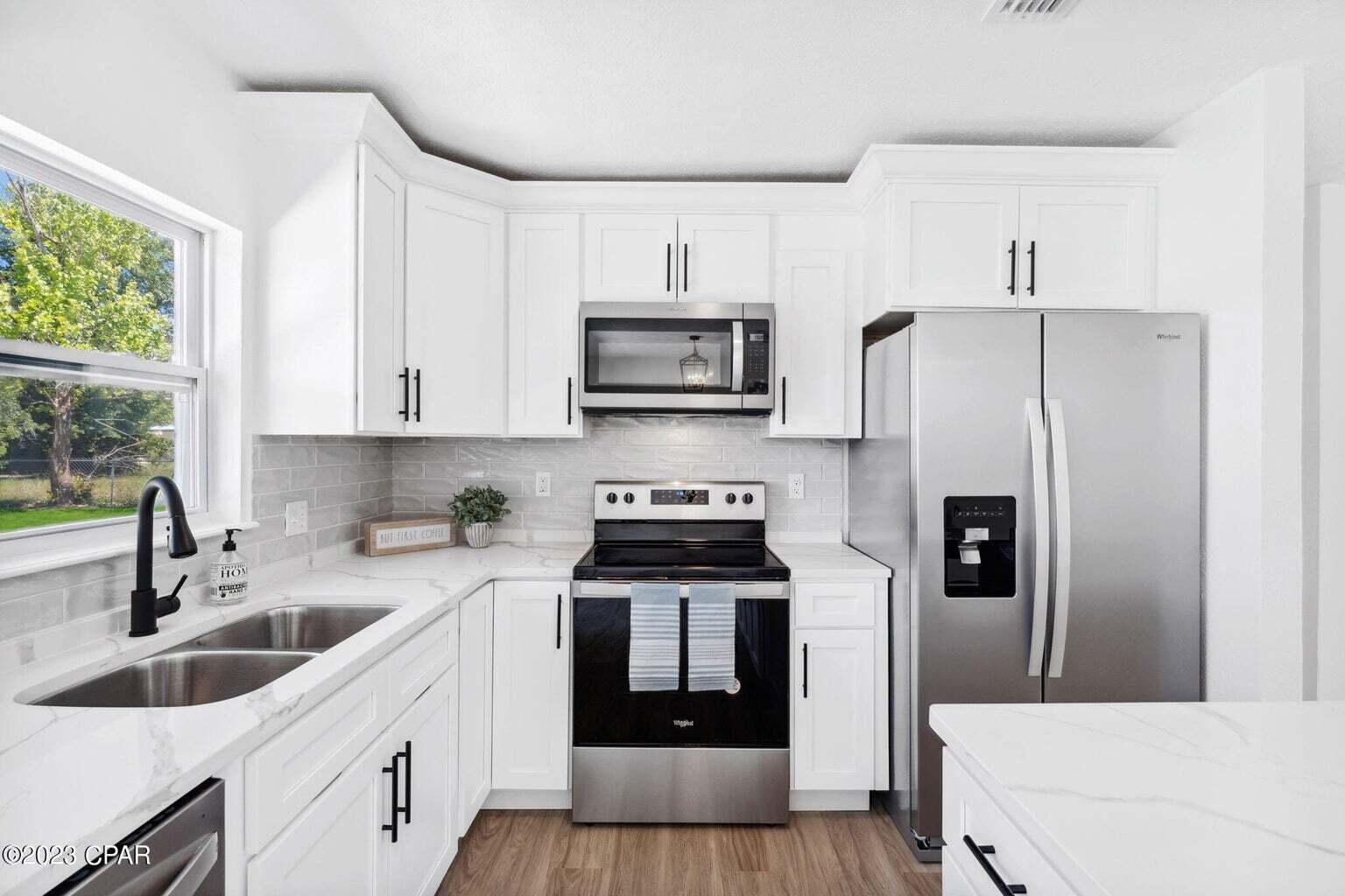 1029 Ethlyn Road Panama City, FL 32404 - Photo 8 of 29 a kitchen with stainless steel appliances a stove a sink a refrigerator and cabinets