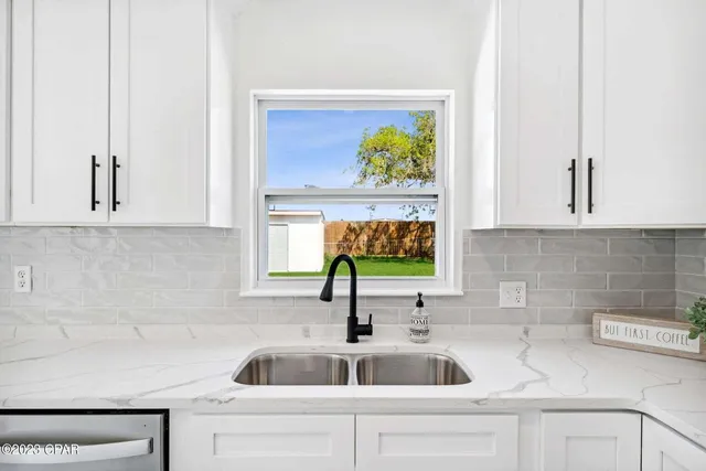 a kitchen with stainless steel appliances white cabinets and a sink