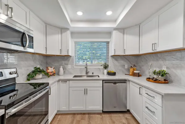 a kitchen with a sink a stove cabinets and window