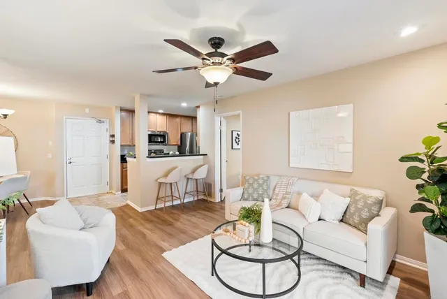 a living room with furniture kitchen view and a chandelier