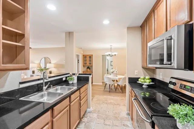 a kitchen with stainless steel appliances granite countertop a sink stove and cabinets