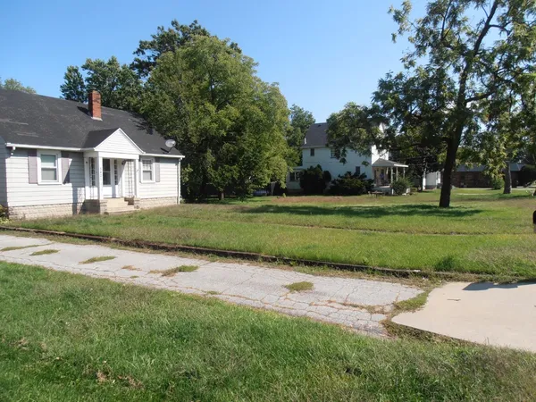 a front view of a house with a yard and trees