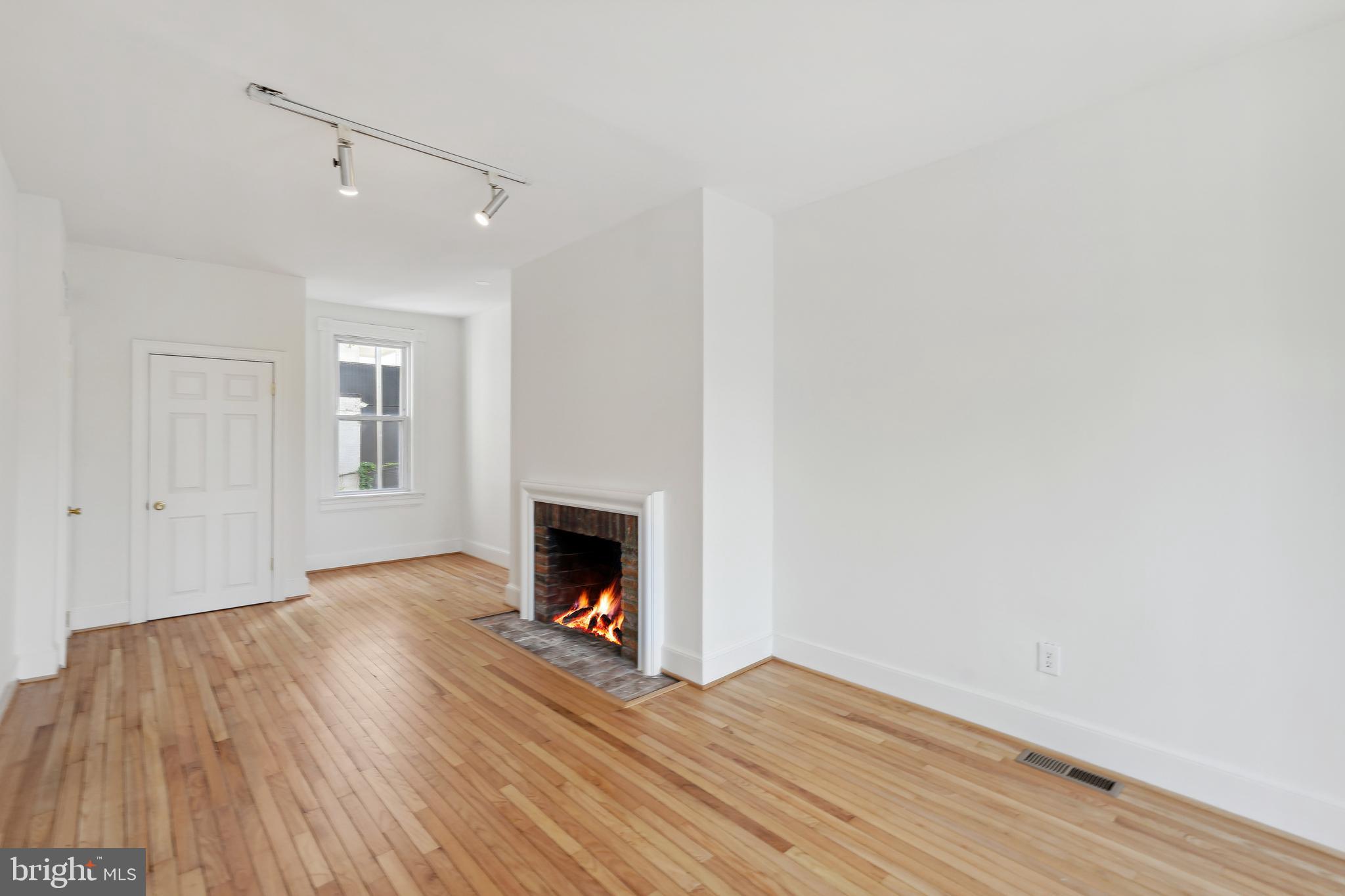 329 Constitution Avenue Northeast Washington, DC 20002 - Photo 30 of 62 a view of an empty room with wooden floor and a fireplace