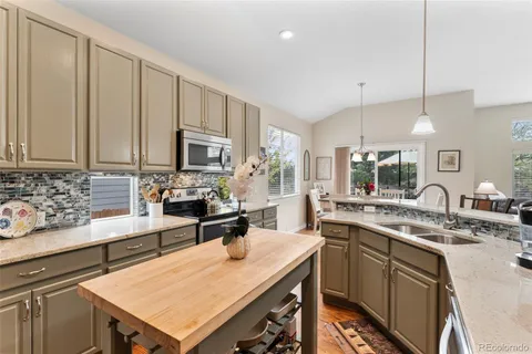 a kitchen with a sink a counter space appliances and cabinets