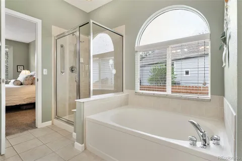 a bathroom with a tub a mirror and a shower