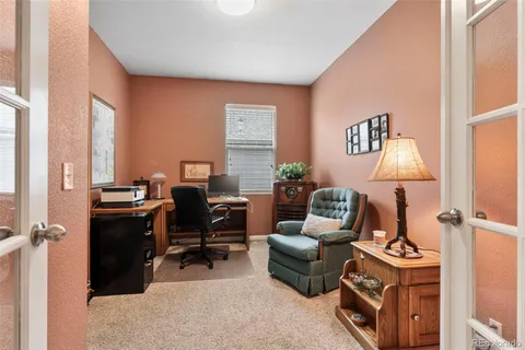 a view of a workspace with furniture and a window