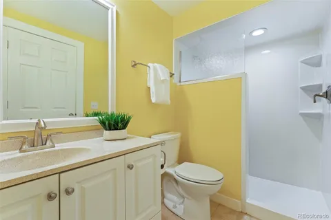 a bathroom with a granite countertop sink a toilet and a mirror