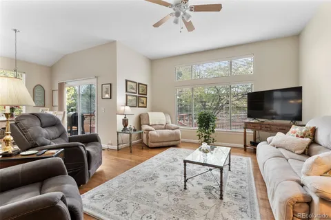 a living room with furniture a flat screen tv and a large window