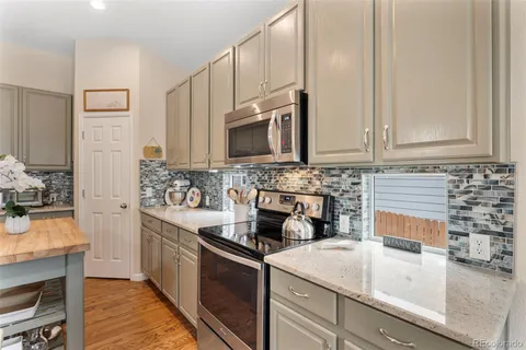 a kitchen with stainless steel appliances granite countertop a sink stove and microwave