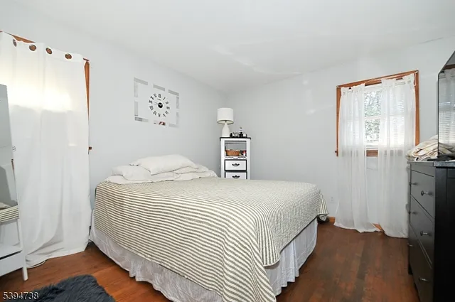 a bedroom with a bed and a refrigerator