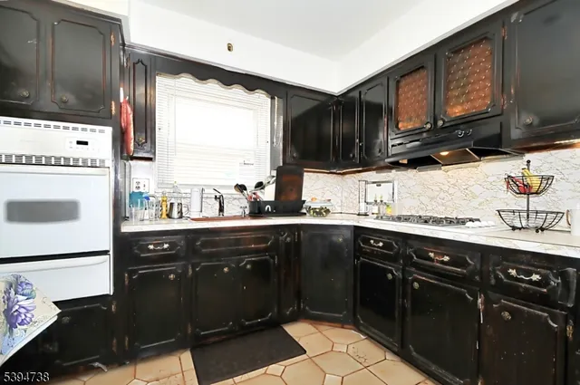a kitchen with a sink stove top oven and cabinets