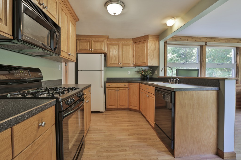 8 Walnut Road Chelmsford, MA 01824 - Photo 9 of 22 a kitchen with granite countertop a sink a counter top space stainless steel appliances a window and cabinets