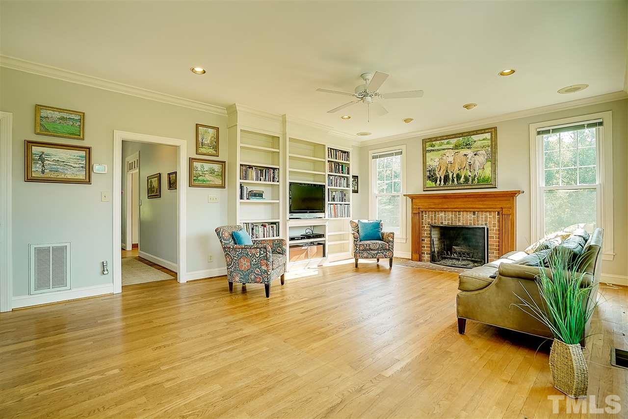 1325 Farmview Road Hillsborough, NC 27278 - Photo 7 of 25 a living room with furniture floor to ceiling window and a fireplace