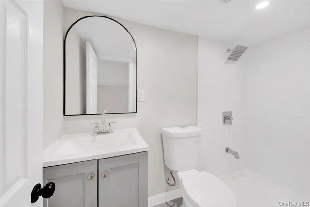 a bathroom with a sink a toilet and a mirror