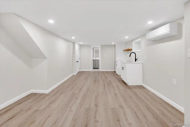a view of a big room with wooden floor and windows