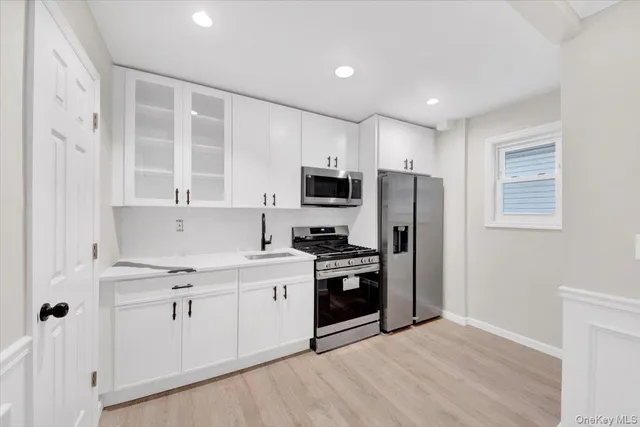 a kitchen with stainless steel appliances granite countertop a stove a sink and a refrigerator