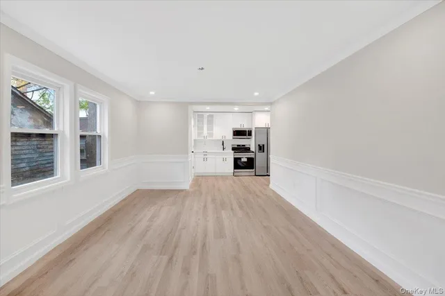a view of empty room with wooden floor and windows