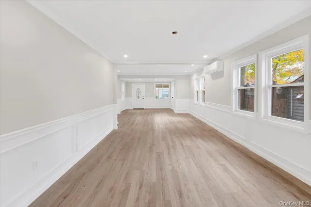 a view of a big room with wooden floor and windows