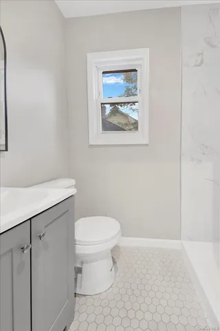 a bathroom with a toilet a sink and mirror