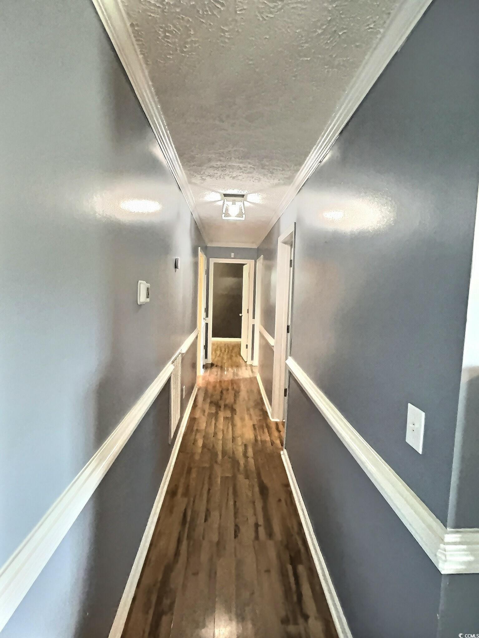 1000 Westgate Place Loris, SC 29569 - Photo 18 of 26 Hallway featuring ornamental molding, a textured ceiling, and dark wood finished floors