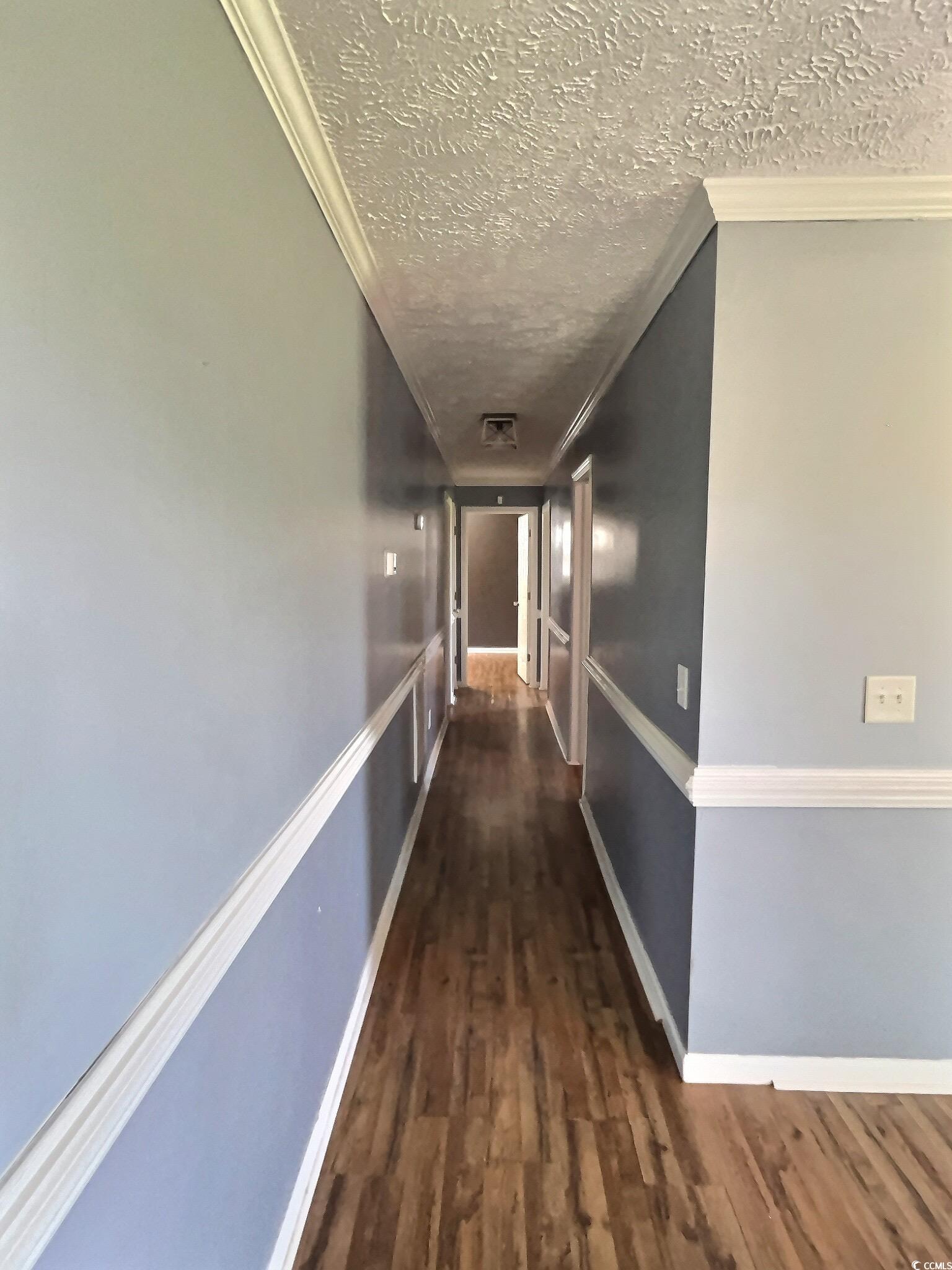 1000 Westgate Place Loris, SC 29569 - Photo 19 of 26 Hall featuring crown molding, dark wood-type flooring, and a textured ceiling