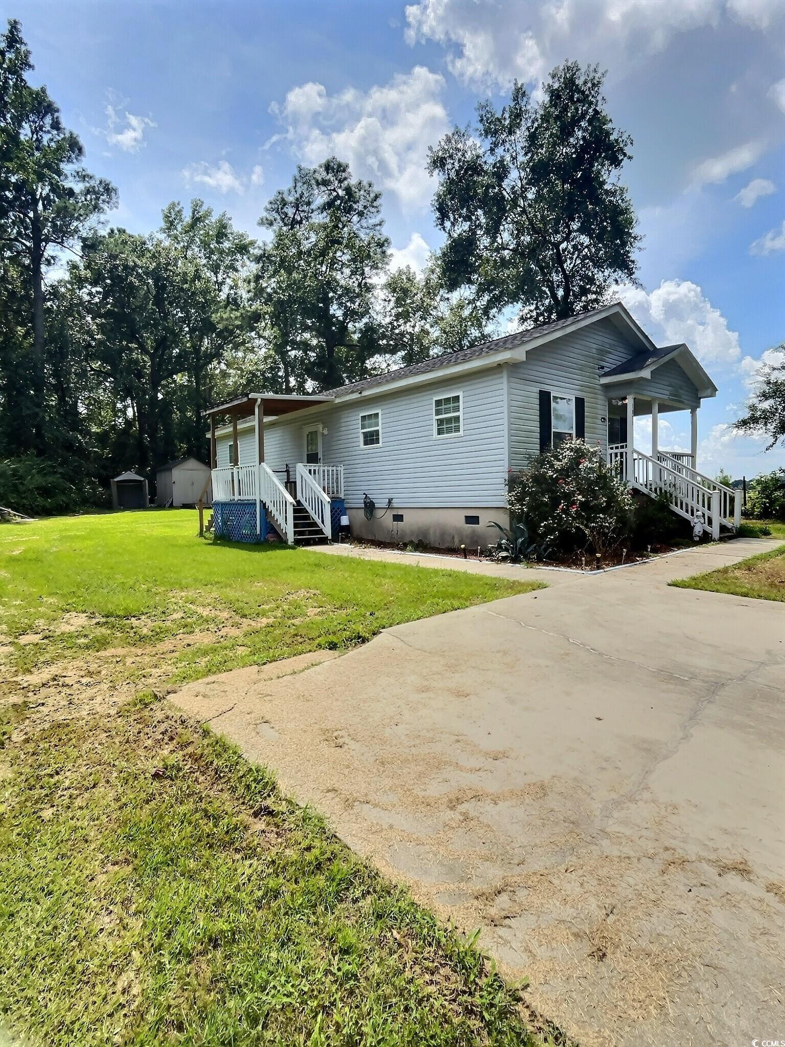 1000 Westgate Place Loris, SC 29569 - Photo 2 of 26 Rear view of house with crawl space, a storage unit, covered porch, and a lawn