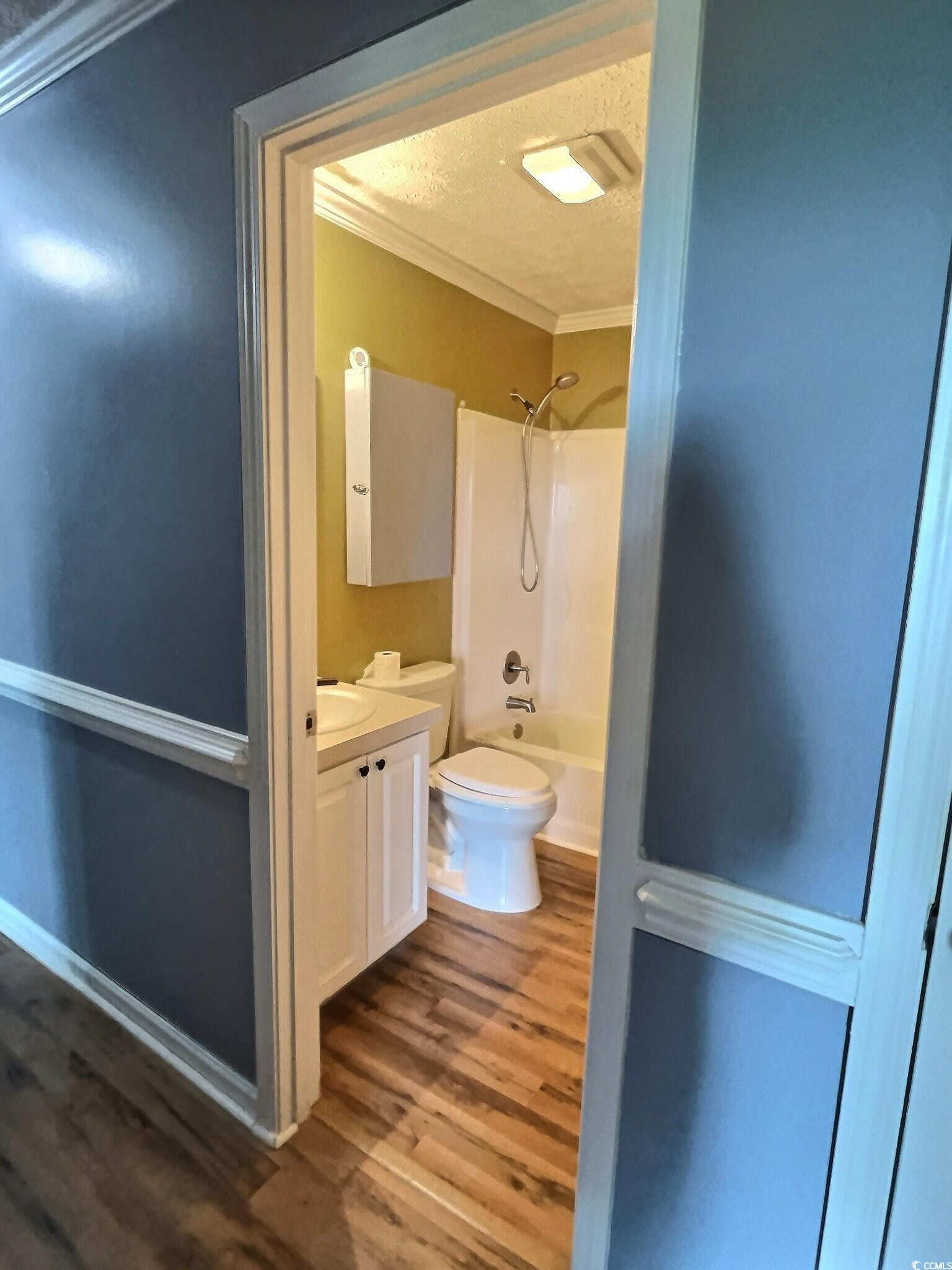 1000 Westgate Place Loris, SC 29569 - Photo 23 of 26 Full bath featuring ornamental molding, a textured ceiling, washtub / shower combination, vanity, and dark wood-type flooring