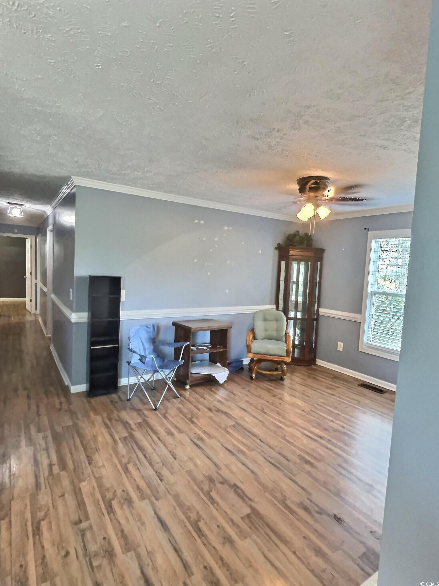 1000 Westgate Place Loris, SC 29569 - Photo 8 of 26 Living area with wood finished floors, crown molding, a textured ceiling, and ceiling fan