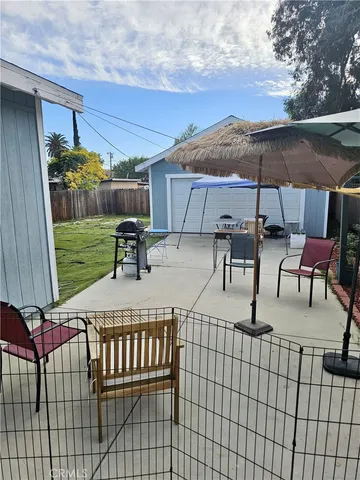 a view of a patio with a table and chairs under an umbrella