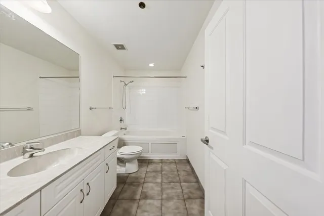 a bathroom with a granite countertop sink a toilet and shower
