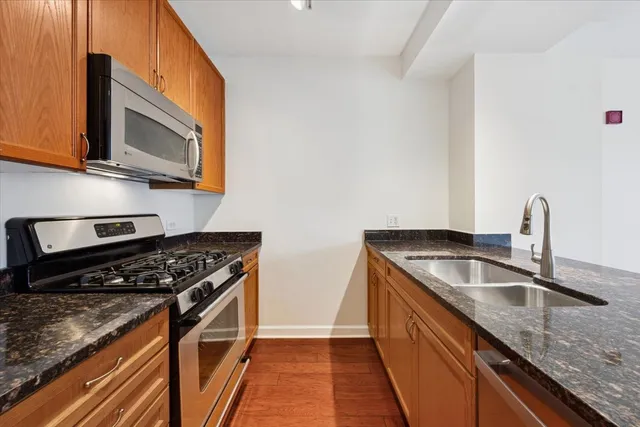 a kitchen with stainless steel appliances granite countertop a sink stove and microwave