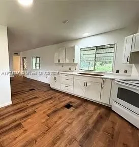 a kitchen with white cabinets sink and white appliances