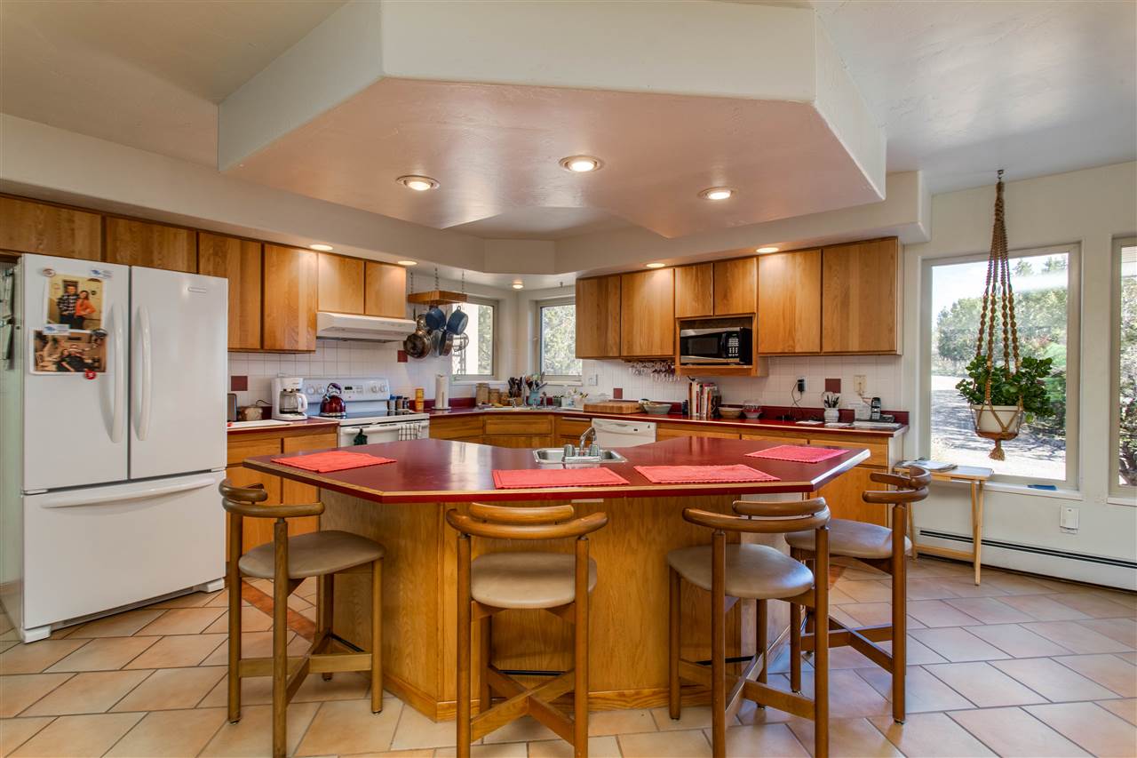18735 Northridge Road Cedaredge, CO 81413 - Photo 10 of 26 a kitchen with stainless steel appliances granite countertop a sink a stove a refrigerator and white cabinets with wooden floor