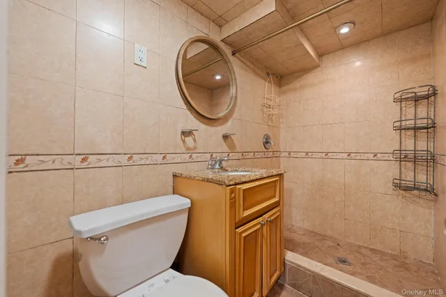 a bathroom with a granite countertop toilet sink and mirror