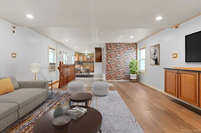 a living room with furniture flat screen tv and large window