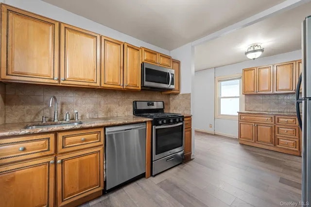 a kitchen with granite countertop wooden cabinets and stainless steel appliances