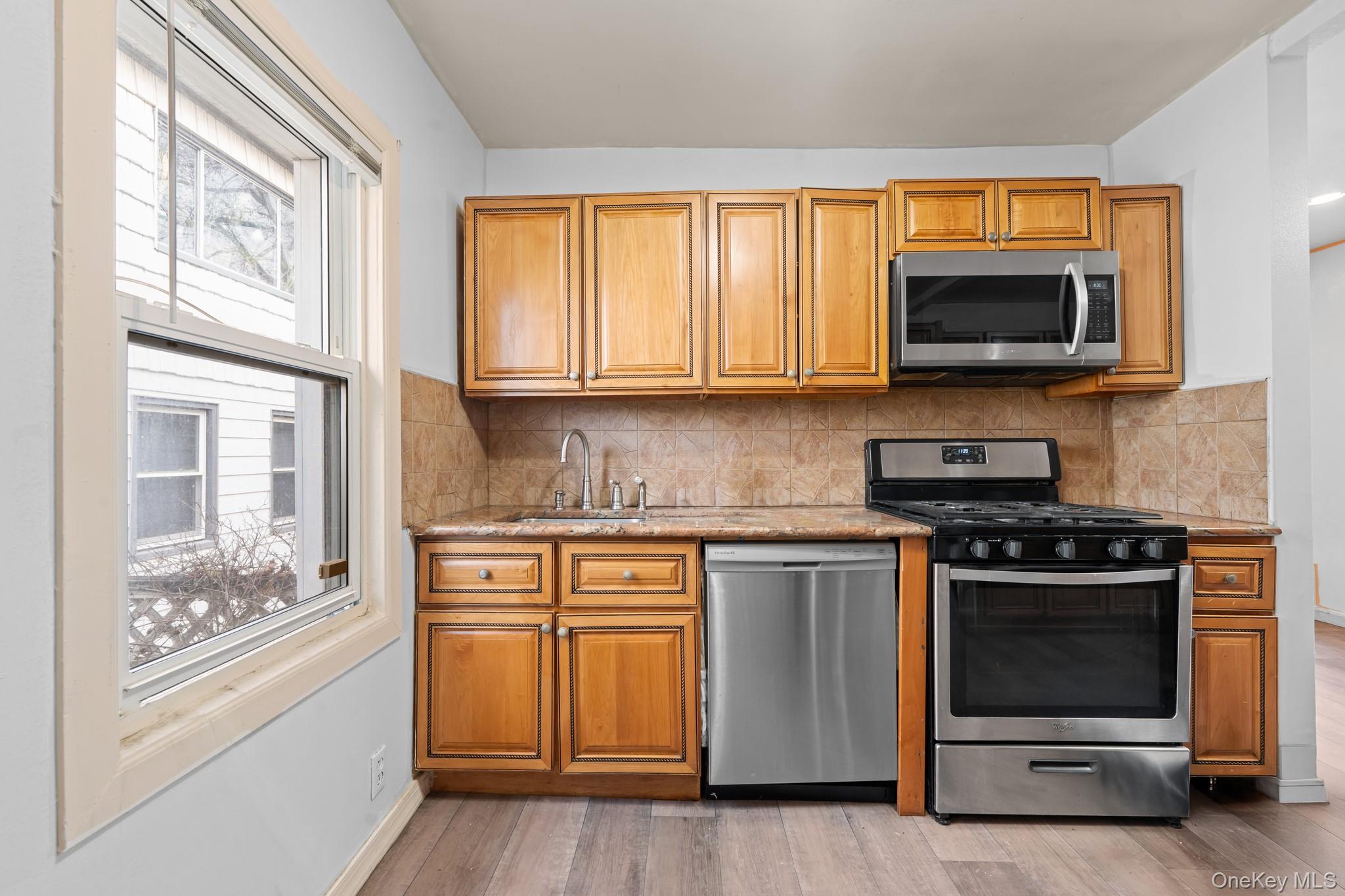 1638 East 45th Street Brooklyn, NY 11234 - Photo 5 of 16 a kitchen with stainless steel appliances granite countertop a stove and a microwave