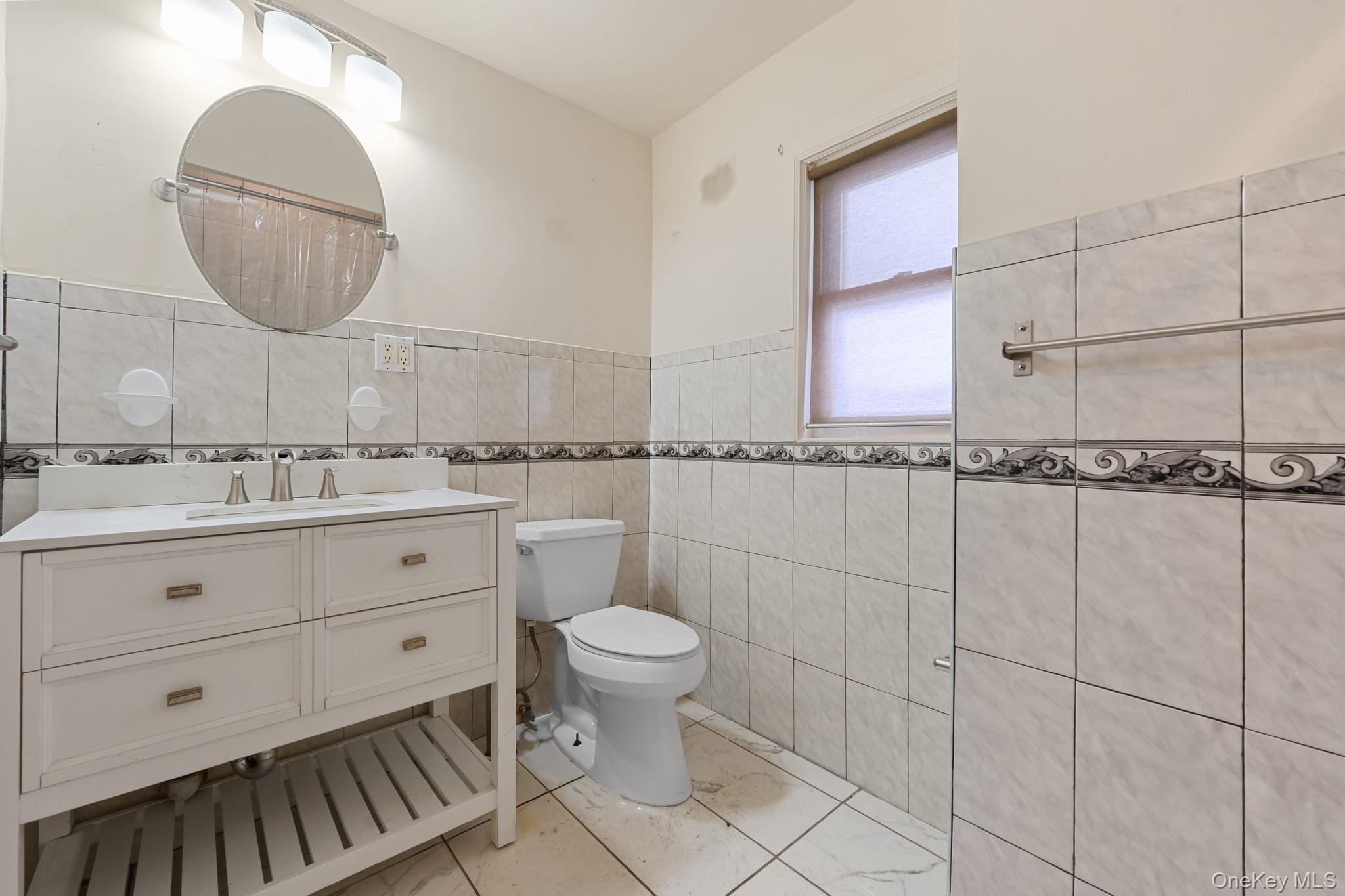 1638 East 45th Street Brooklyn, NY 11234 - Photo 6 of 16 a bathroom with a toilet a sink and mirror