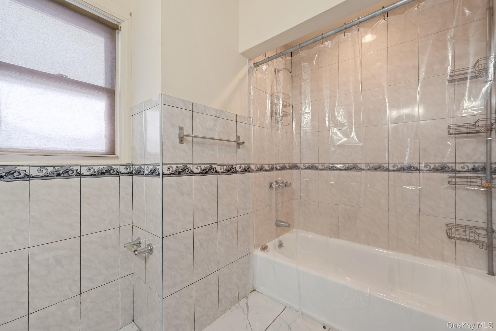1638 East 45th Street Brooklyn, NY 11234 - Photo 7 of 16 a bathroom with a bathtub and a shower